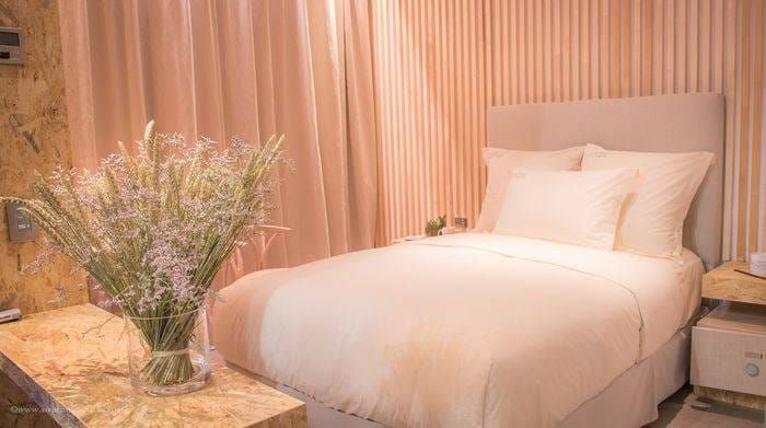 La Chambre ORIGINE® construite à EquipHotel 2016 : lit aux draps blancs, parois en lames de bois et bouquet de lavande